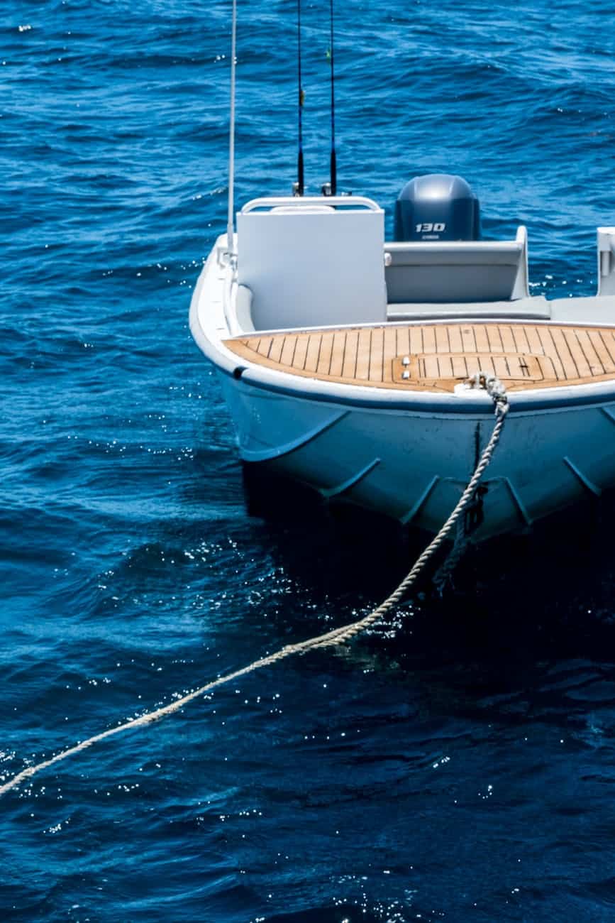 a boat with rope near dock showing its dirty gelcoat hull