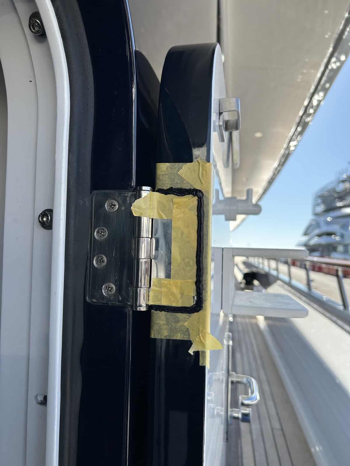 Hinge being sealed in with marine caulking.