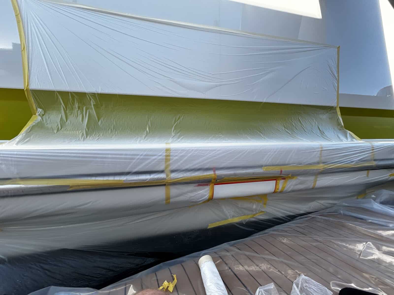 boat paint job with white paint and tented area ready for spraying. 