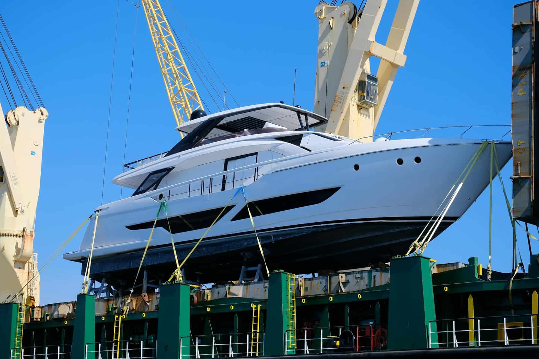 luxury yacht hoisted by crane at marina