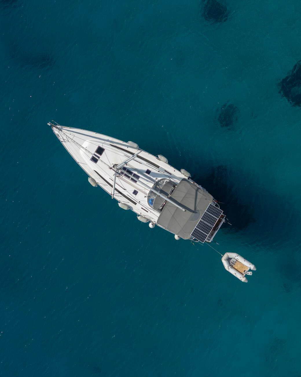 luxury yacht in clear blue water from above 