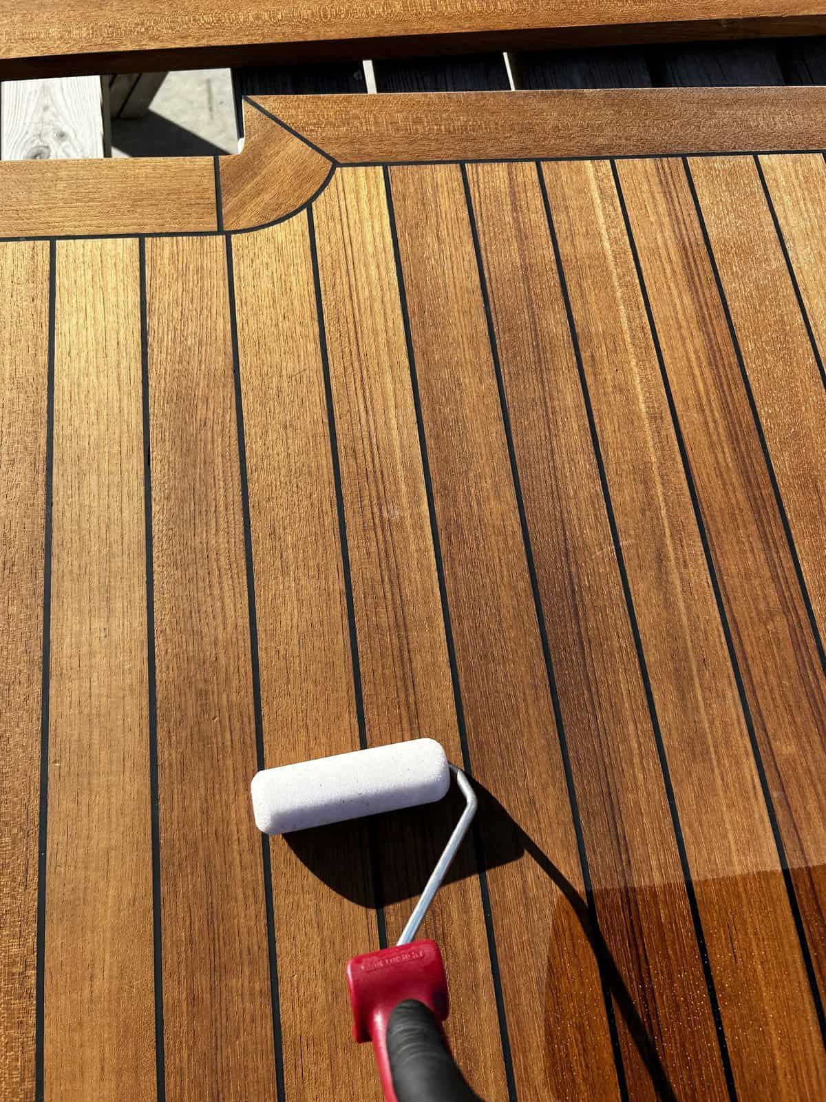 Sealing Teak Foam roller being used in sealing teak deck board with caulking.