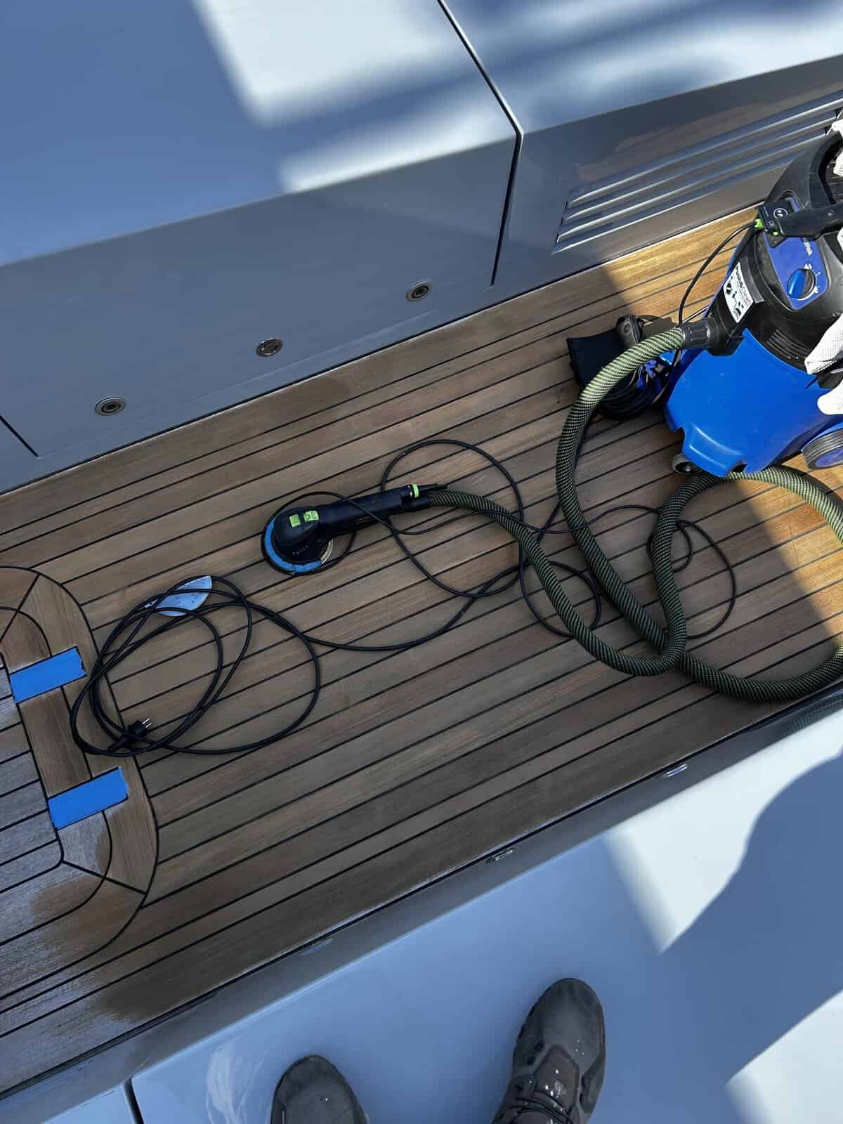 Teak deck sanding being completed using a machine orbital sander. 