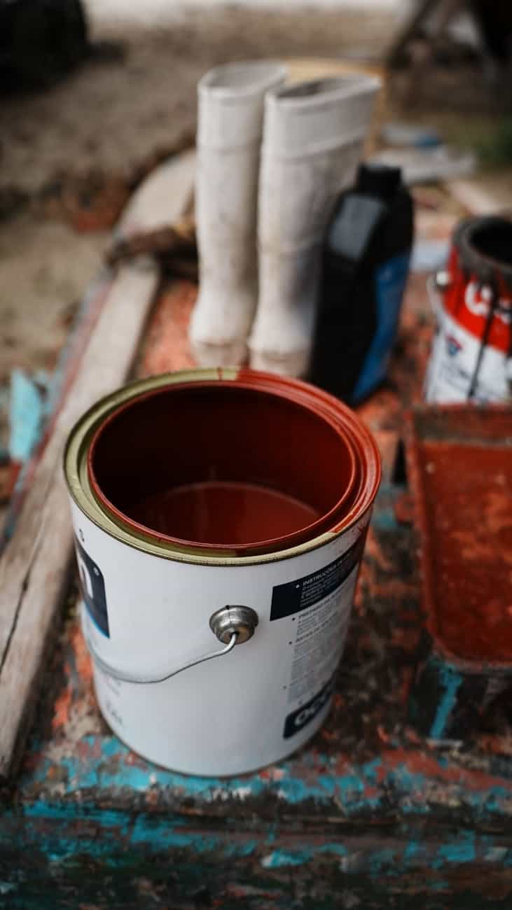 Red boat paint in a tin being mixed ready to use. 