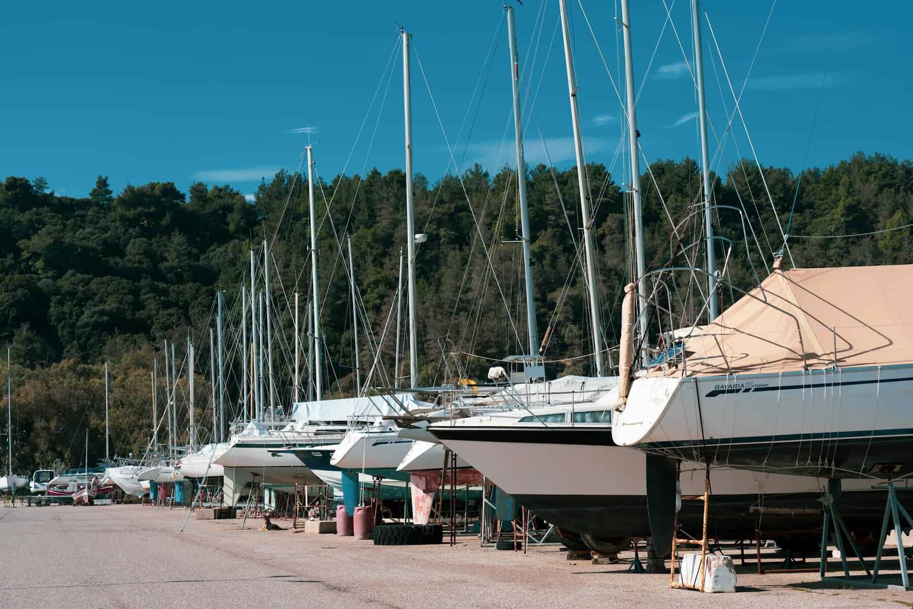 Yacht Maintenance Costs A line of smaller sailing yachts lined up on the hard standing concrete. Showing further yacht maintenance costs.