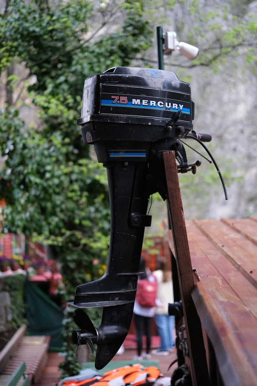 Black mercury outboard engine mounted on a wooden frame.