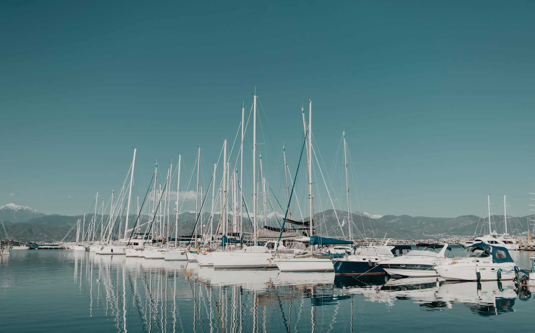 white boats on sea under blue sky