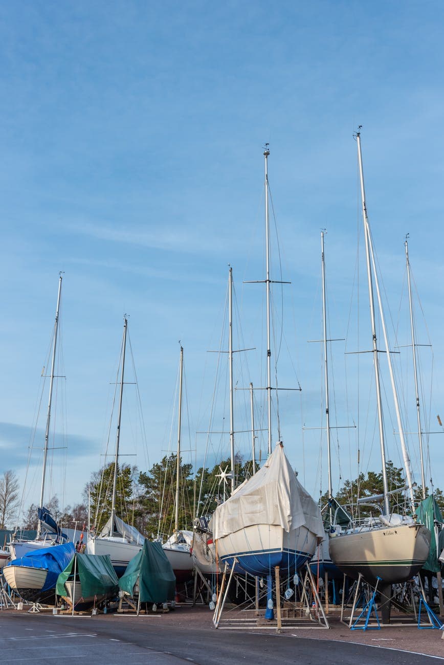 Yachts being held up in the yard on the concrete. 