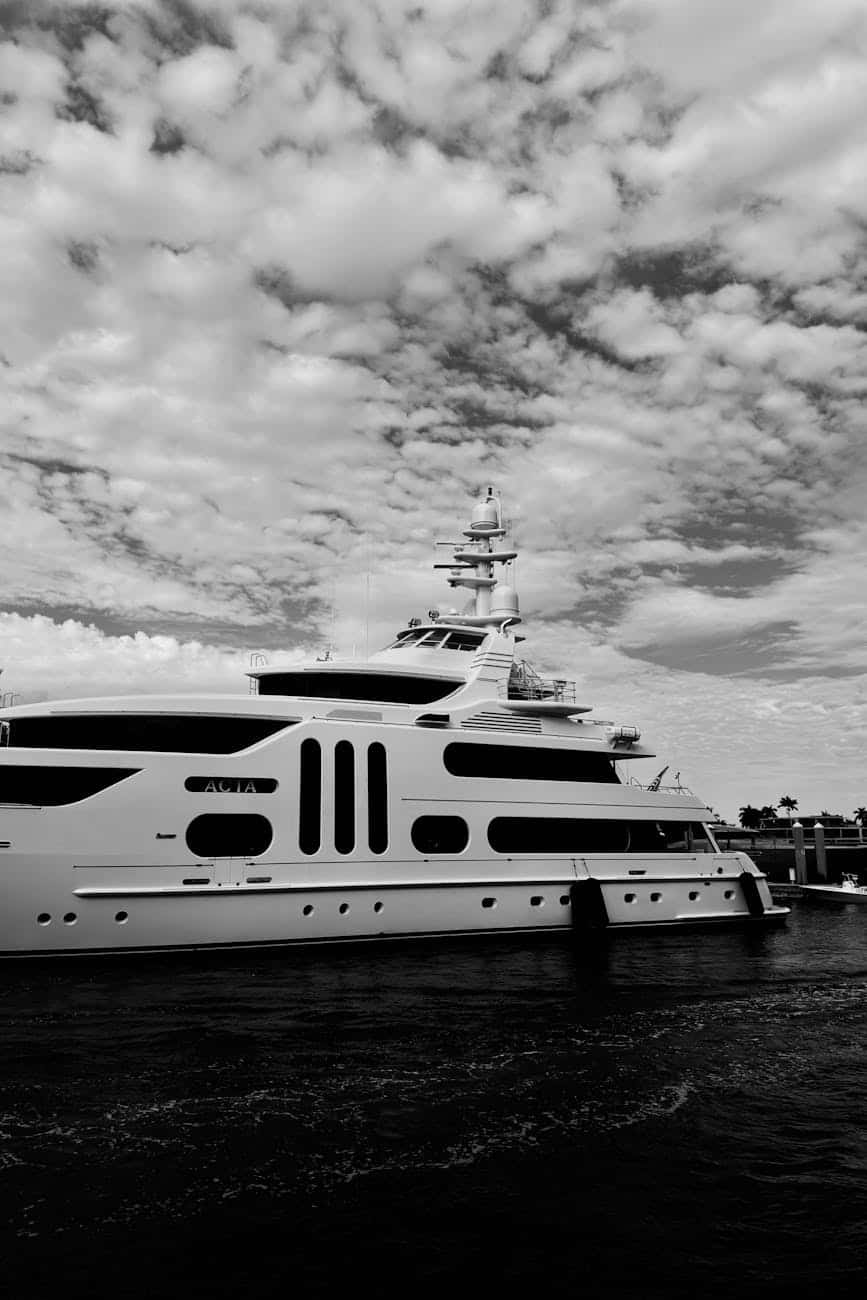 black and white photograph of luxury yacht on water showing lots of windows. 