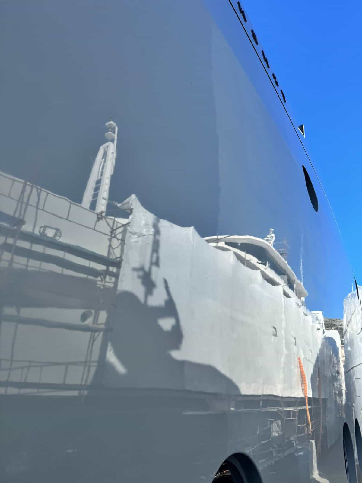 Grey hull of yacht being waxed with the best bot waxes. 