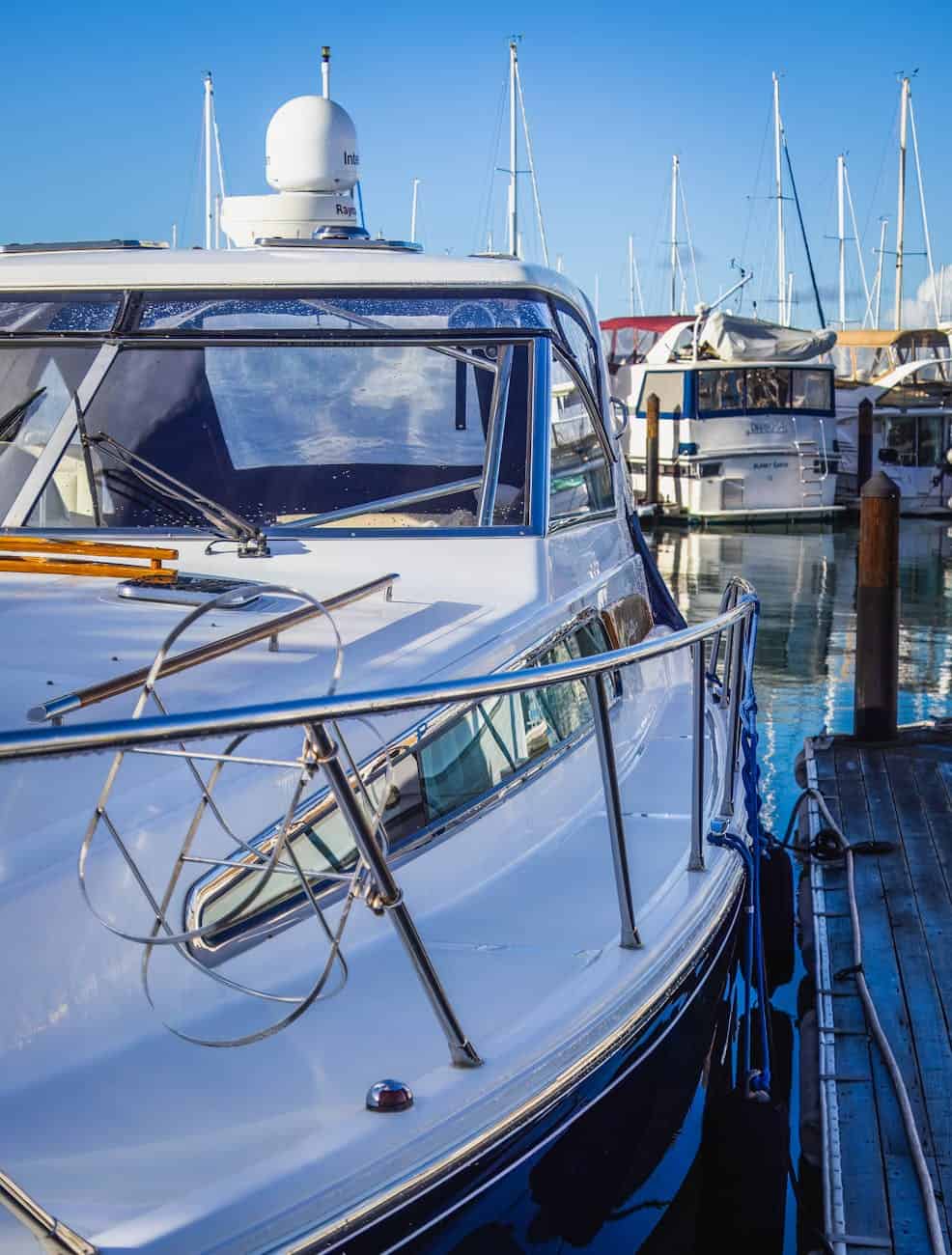 White speed boat with stainless steel railing moored on the dock. 