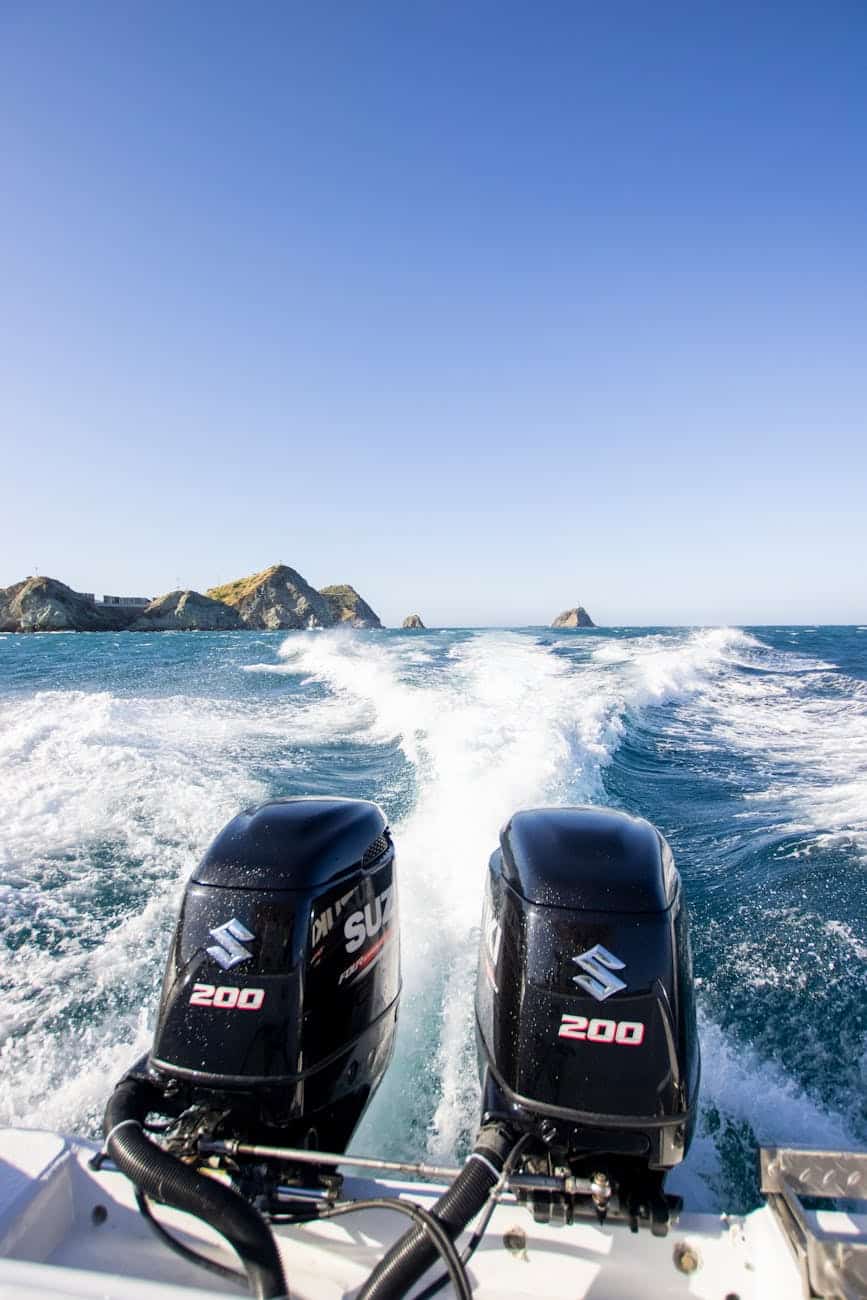 speedboat cruising on a clear blue ocean with 2 suzuki 200 HP engines.