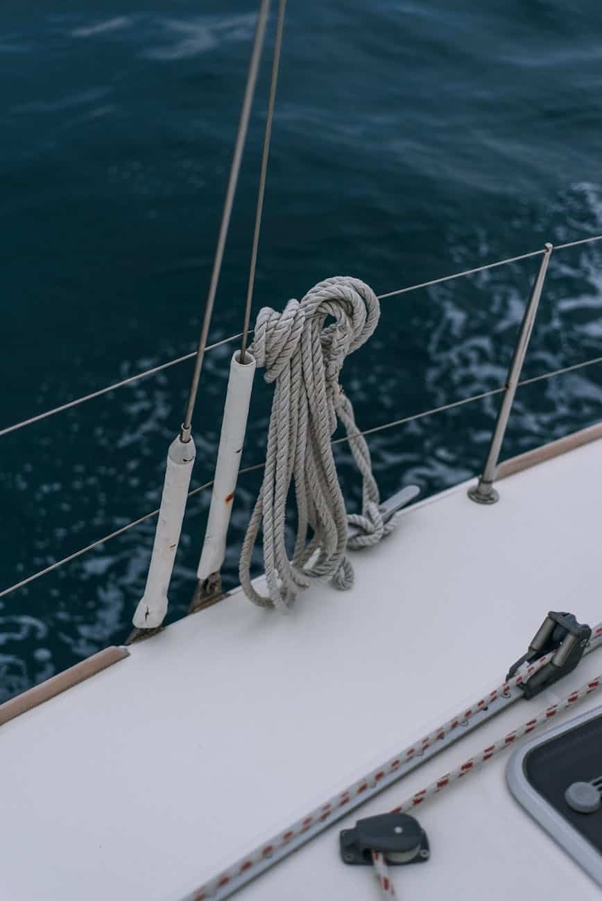 White GRP non skid yacht deck on a sailing yacht with line on the guard rail. 
