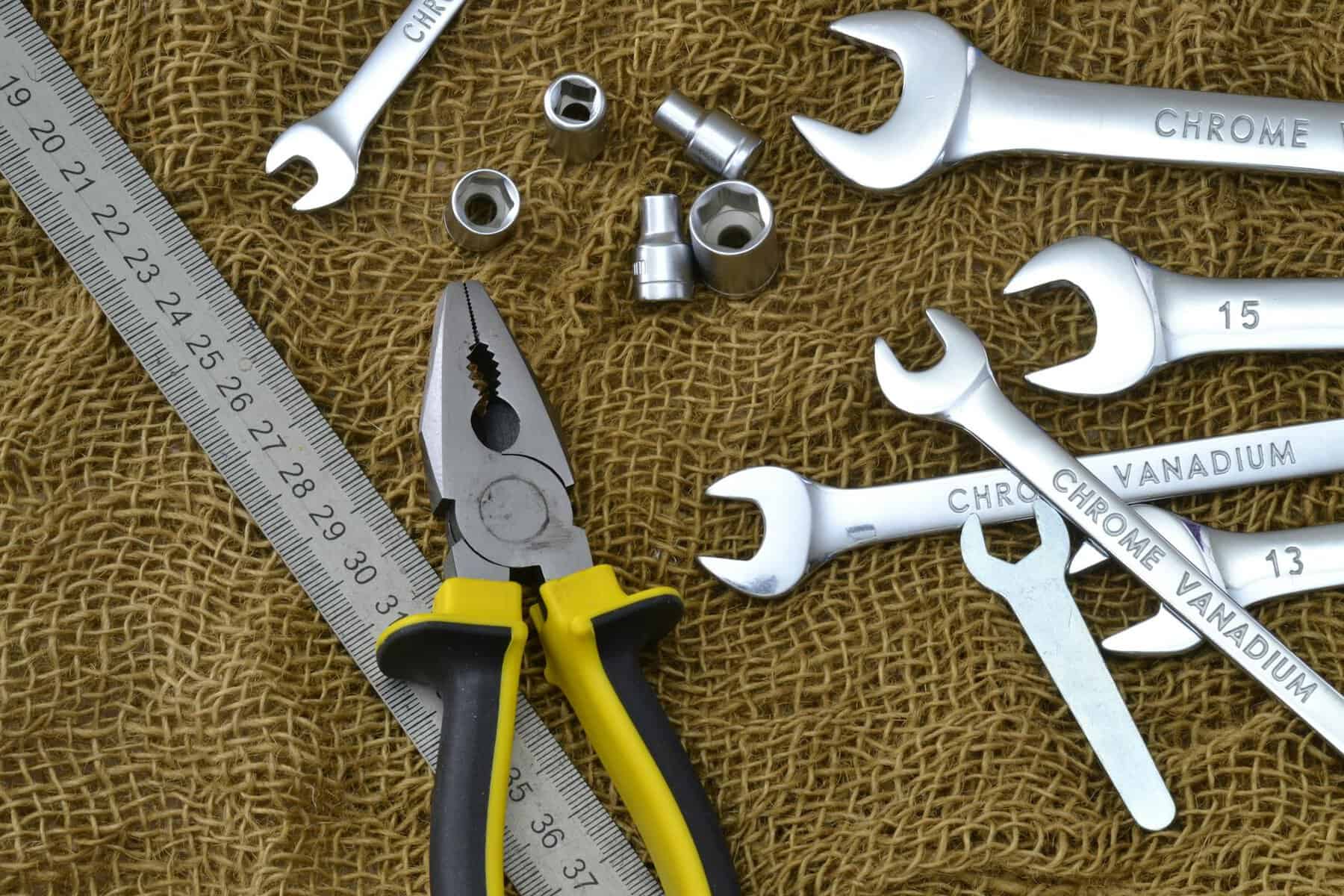 Essential Tools for Boat Maintenance Pliers, rule and spanners on a brown mesh.