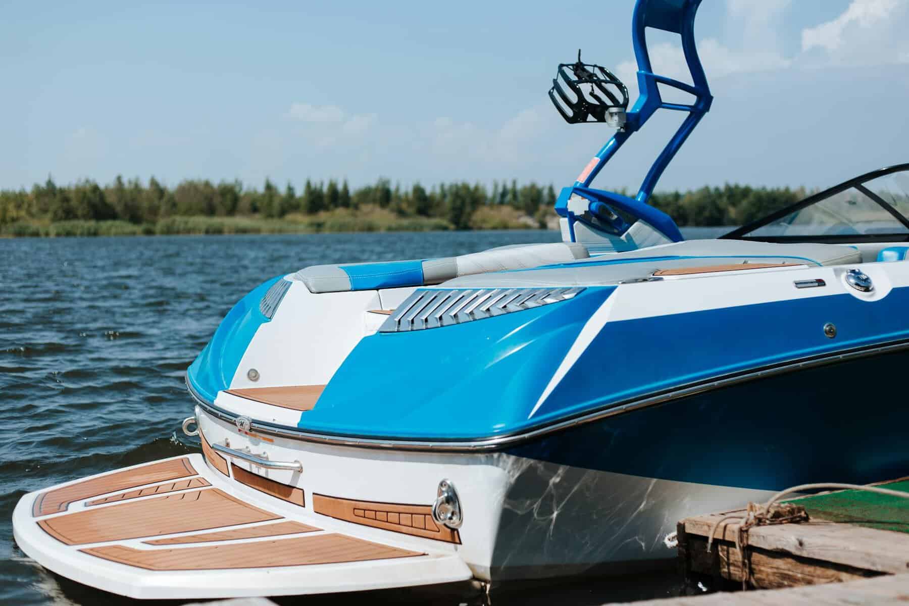Waterski boat docked in marina. With shinny blue paint and fake teka decking. 