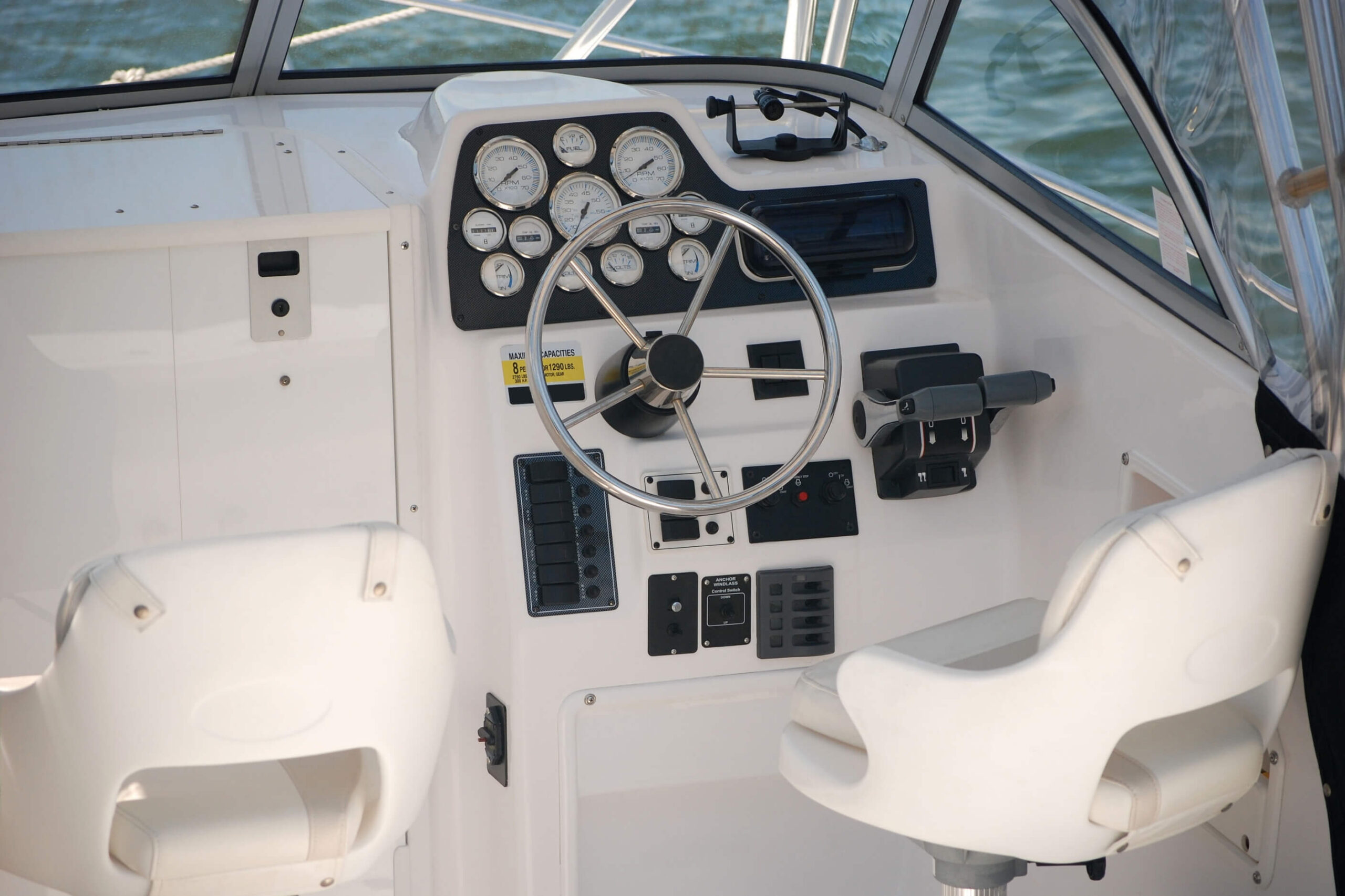 Boat seats in the cockpit of a white twin engine speed boat. 