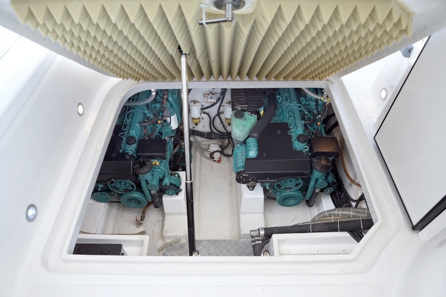 Floor of a white yacht propped open showing 2 marine diesel engines underneath the floor. 