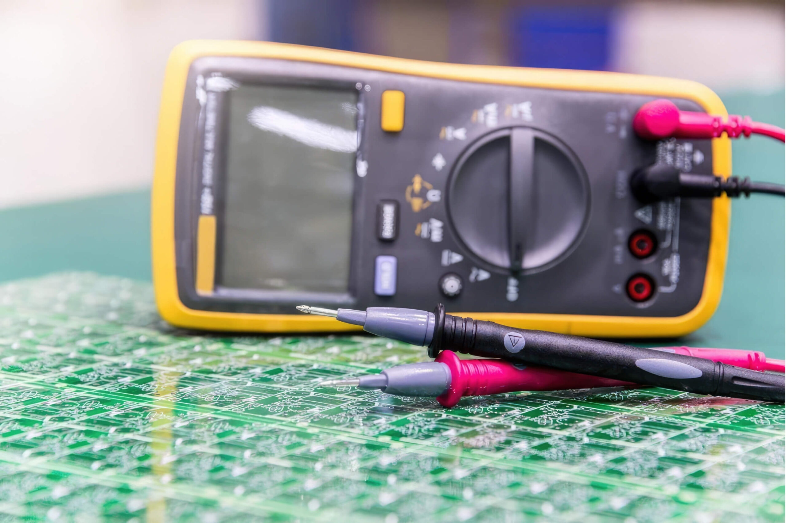 Yellow multimeter with positive and negative cables plugged in. 
