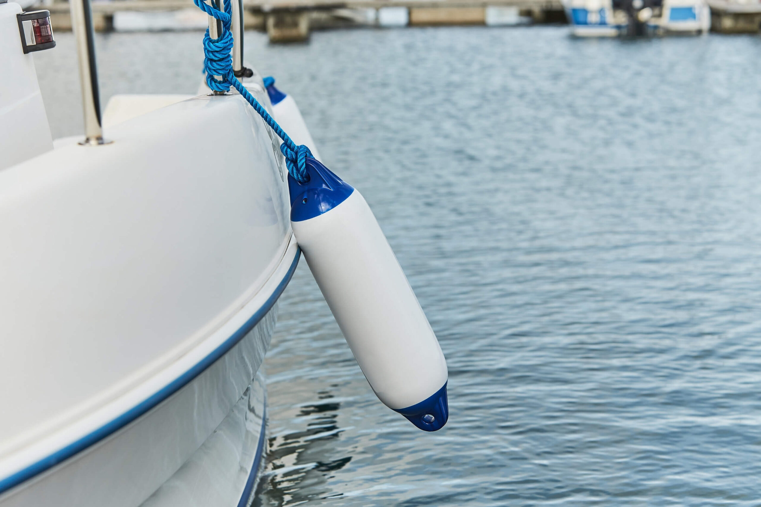 Clean boat fender tided to the stainless railing of a yacht.