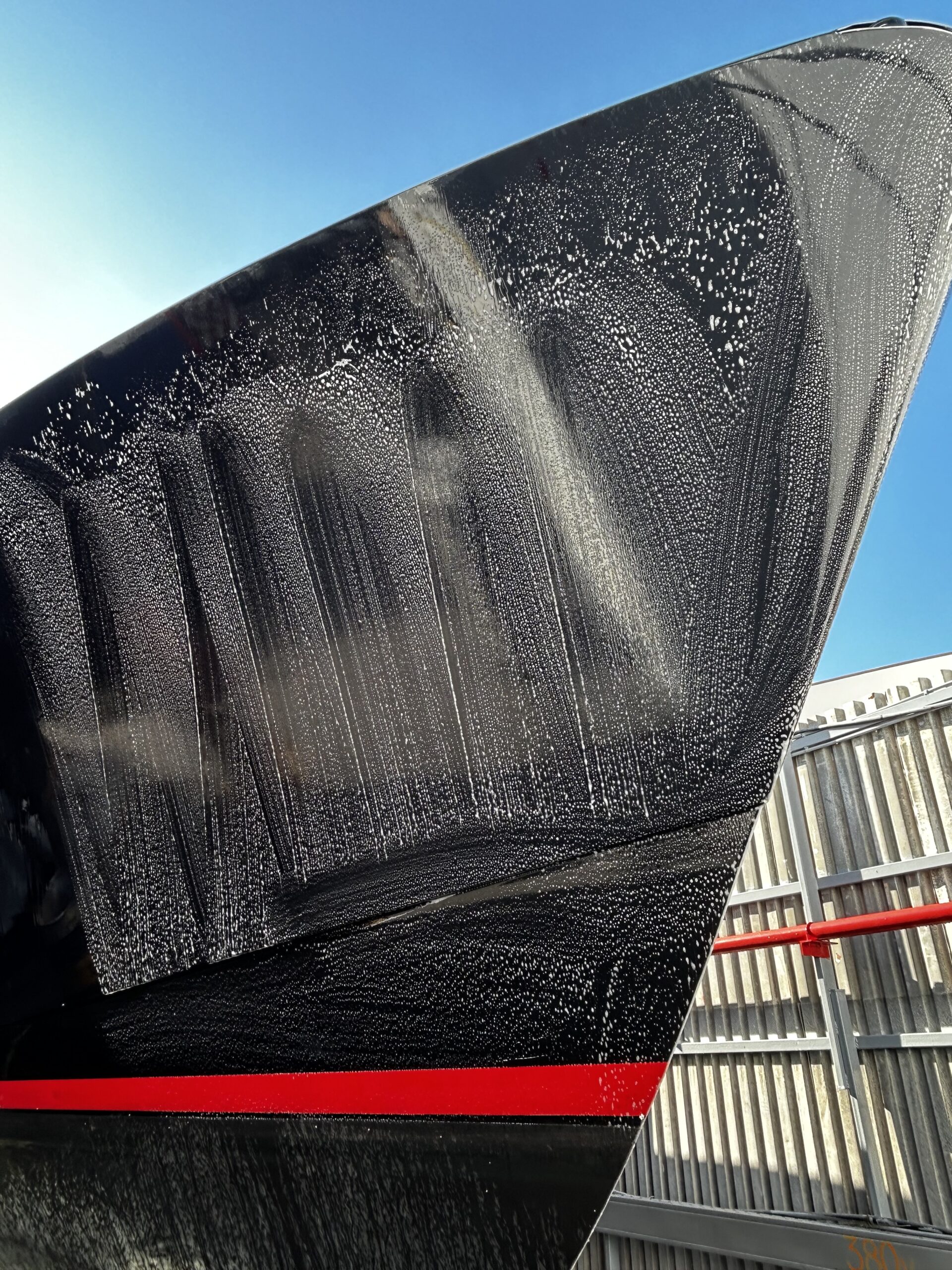 Boat soap on a hull of black power boat. 