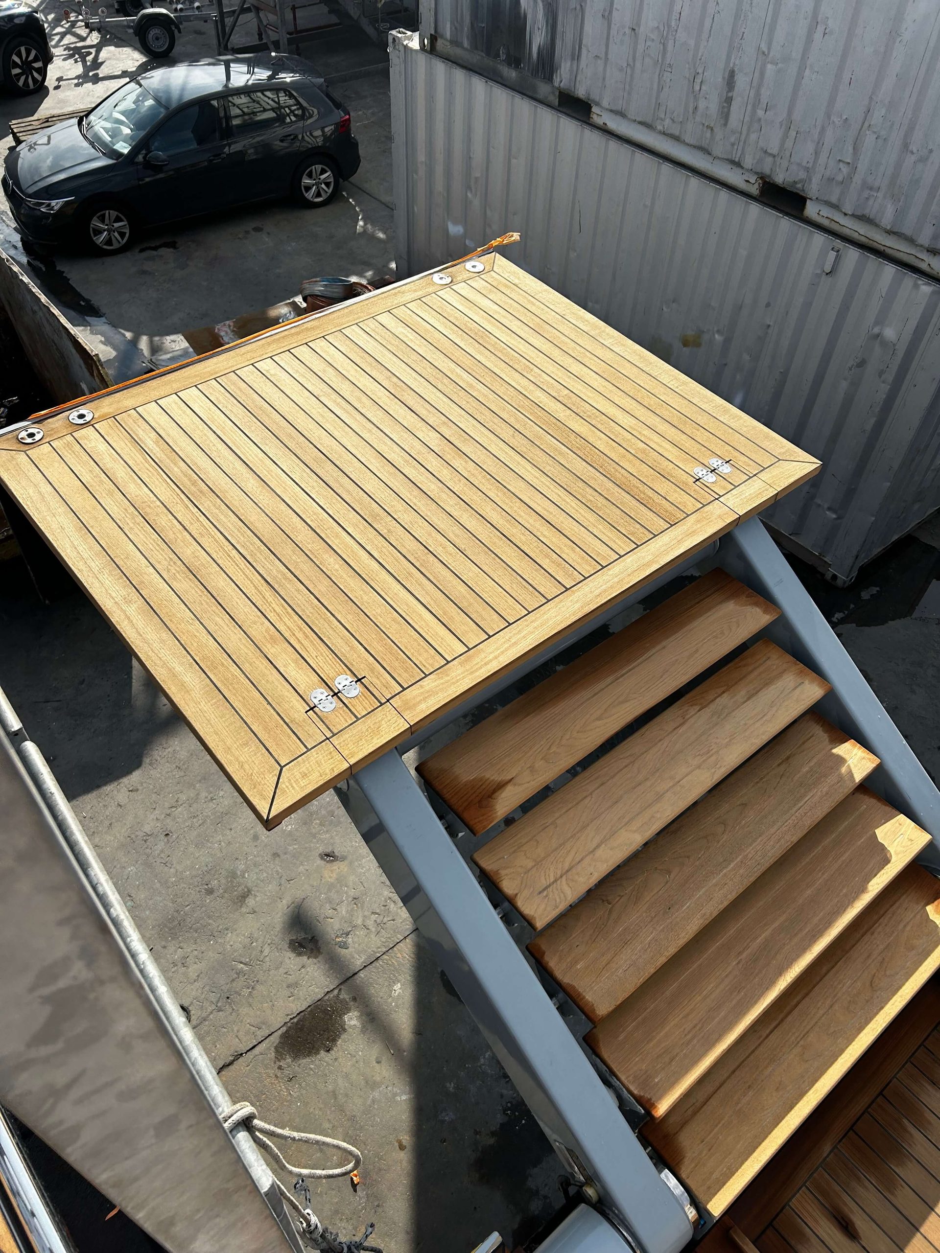 Teak decking retractable platform being extended. 