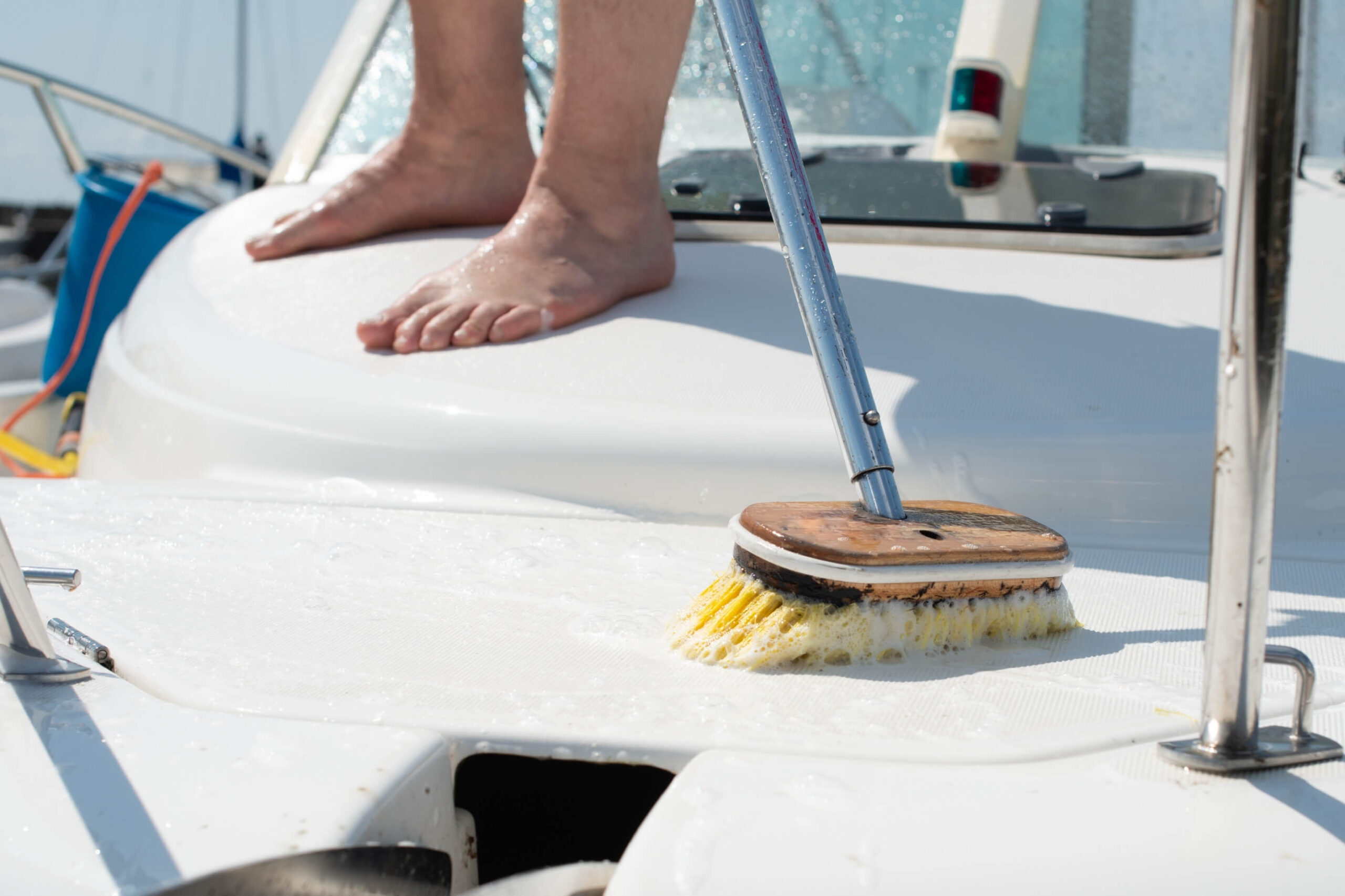 Nonskid boat deck being cleaned with a yellow bristle brush. 