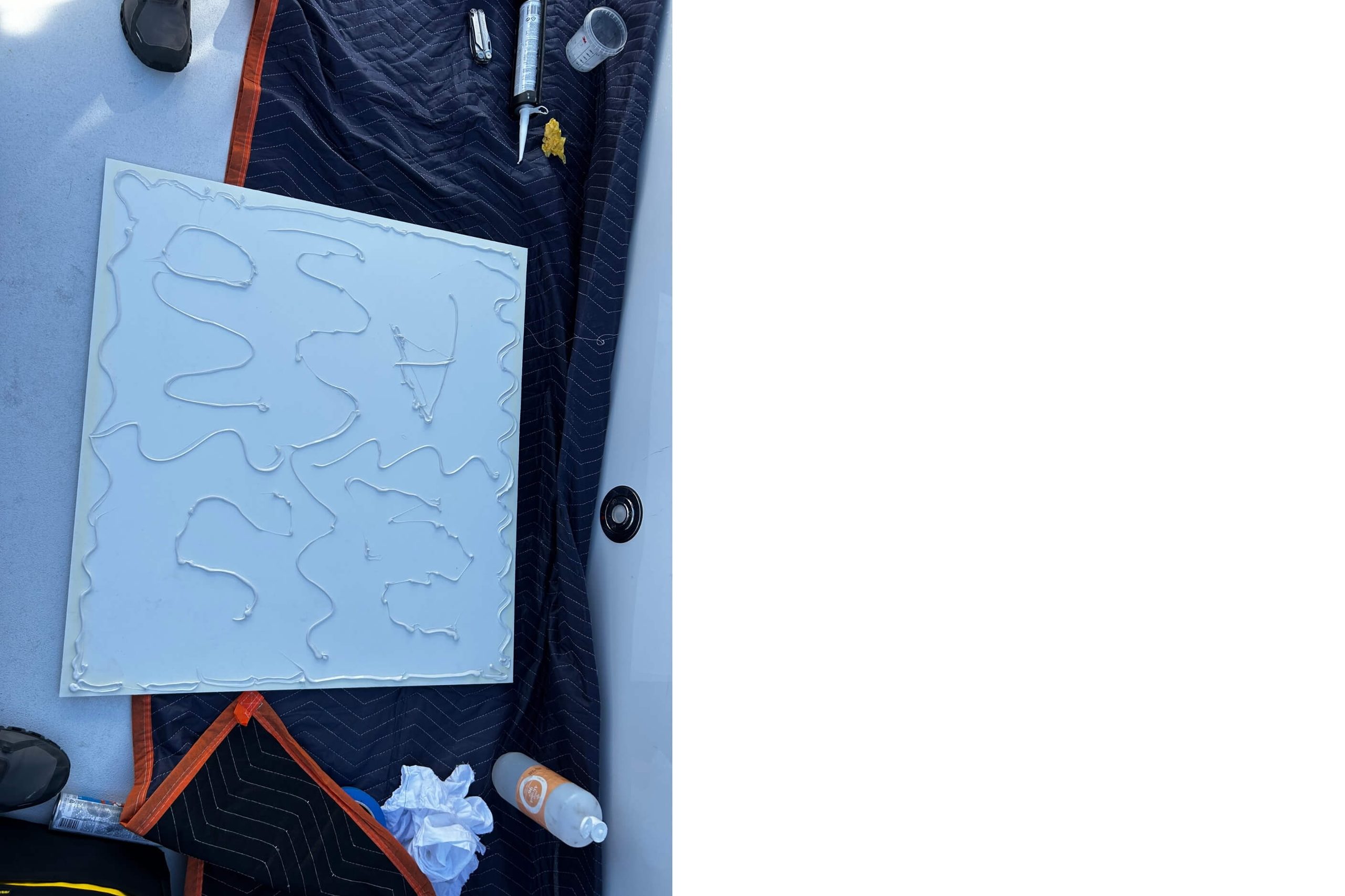 White marine glue being used to stick a white board.